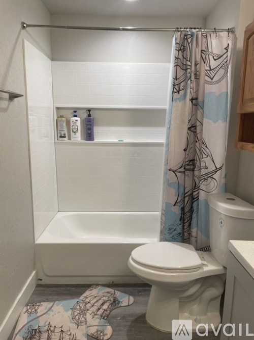 A bathroom with a toilet, a bathtub, and a shower curtain.