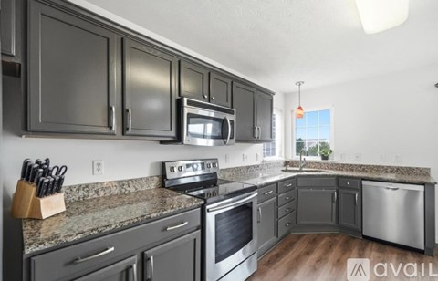 A kitchen with dark cabinets and stainless steel appliances.