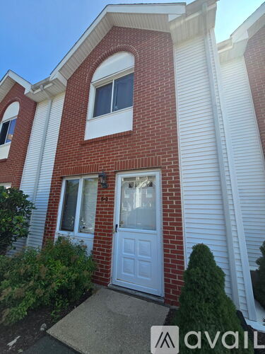 A red brick house with a white door and window.