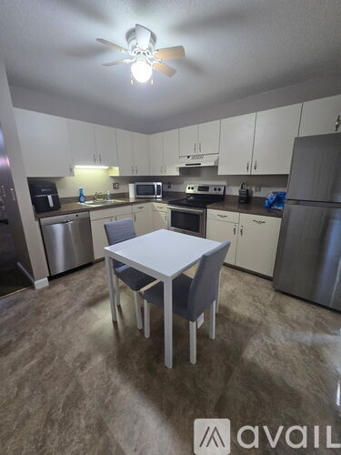 A kitchen with a table and chairs in the middle of it.