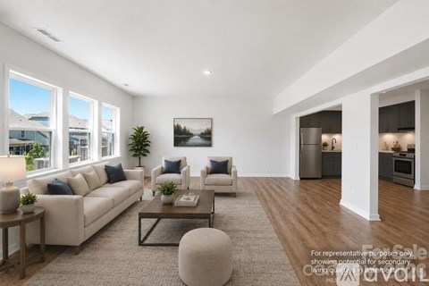A well-lit living room with a large window, a sofa, a coffee table, and a painting on the wall.