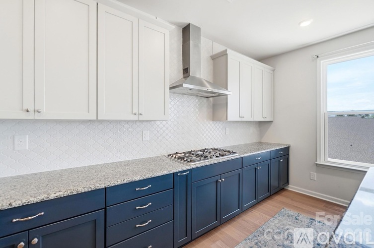 A kitchen with white cabinets and a blue counter.