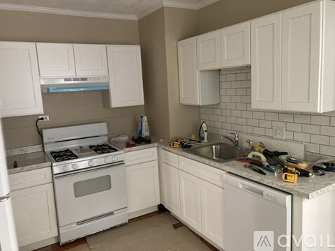 A kitchen with white cabinets and appliances is undergoing renovations.