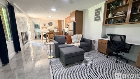 A living room with a grey couch and a black chair.