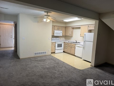 A kitchen with white appliances and wooden cabinets.