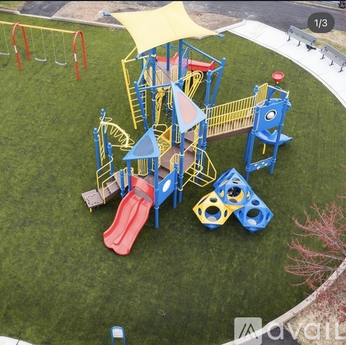 A playground with a red slide and a yellow canopy.