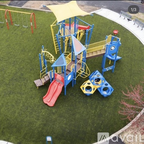 A playground with a red slide and a yellow canopy.