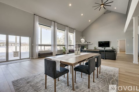 A modern dining room with a large table and chairs.