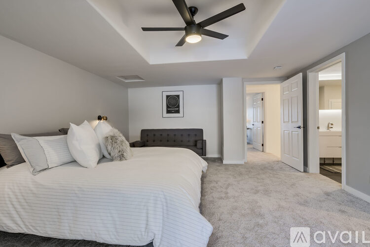 A bedroom with a large bed and a ceiling fan.