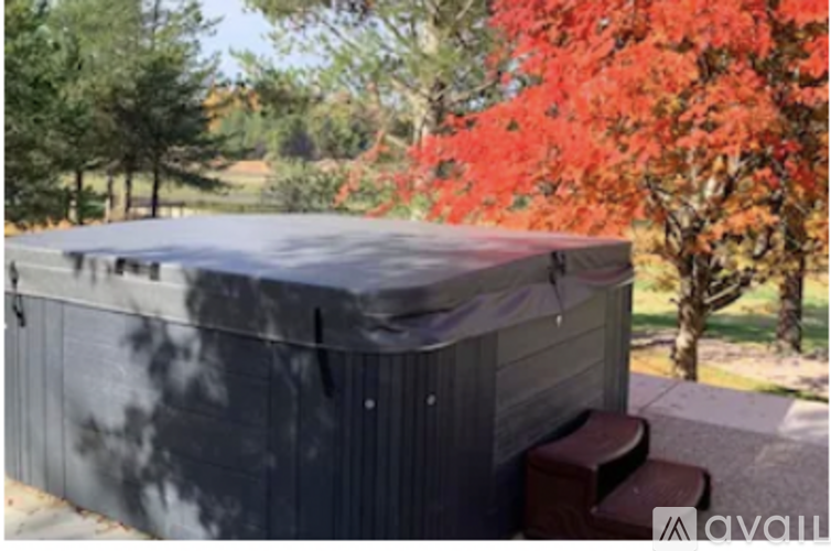 A grey covered hot tub sits on a patio.
