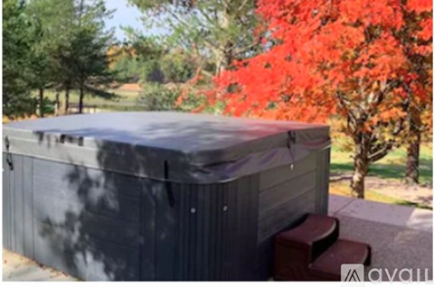 A grey covered hot tub sits on a patio.