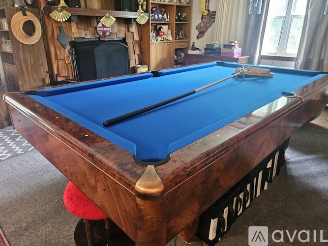 A pool table with a blue cloth and a white cue ball.
