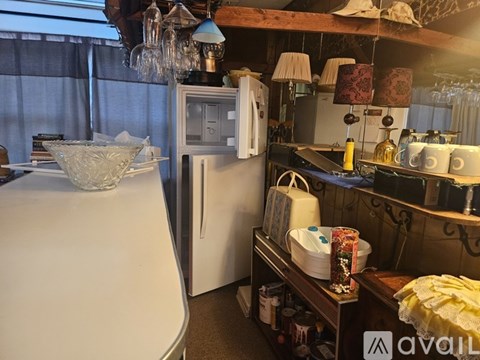 A kitchen with a white refrigerator and a white counter.