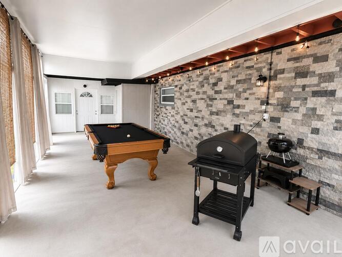 A room with a pool table and a brick wall.