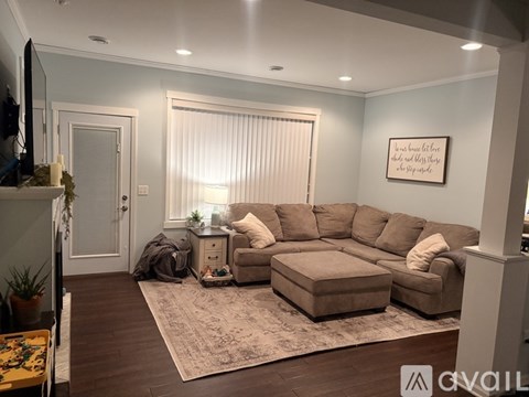 A living room with a large sectional sofa and a rug.