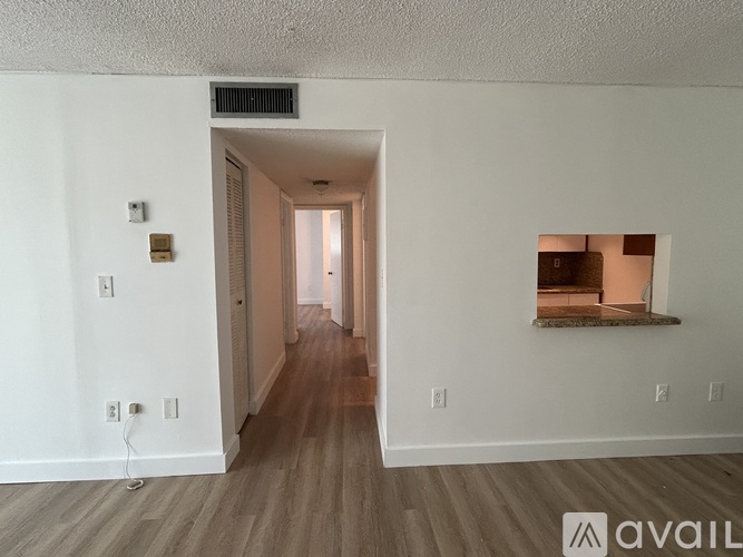 A room with a wooden floor and a window on the right side.