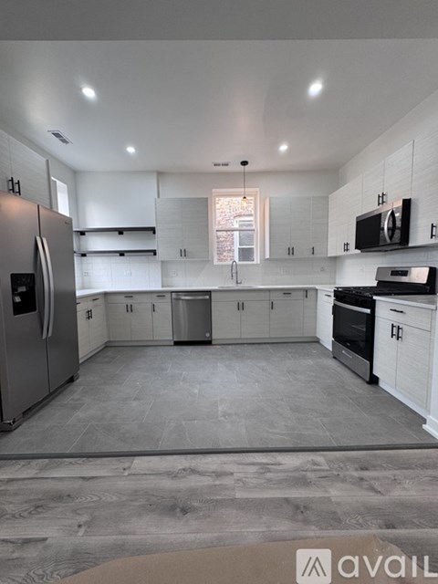 A modern kitchen with white cabinets and stainless steel appliances.