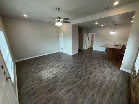 A room with wooden flooring and a ceiling fan.