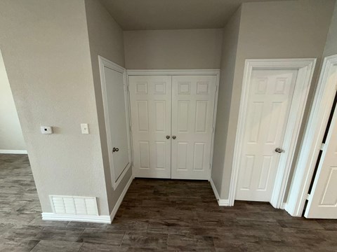 A room with a white door and a white cabinet.