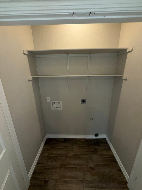 A small, empty room with a shelf and a door.