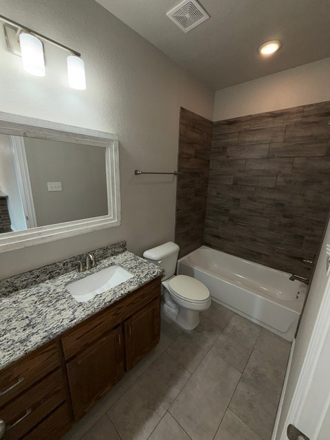 A bathroom with a sink, toilet and bathtub.