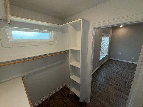 A room with a window and a shelf is shown.