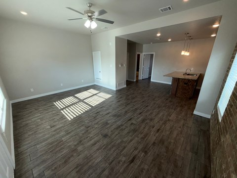 A room with wooden flooring and a ceiling fan.