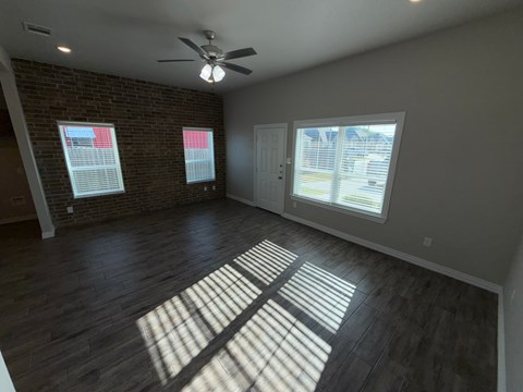 A room with a ceiling fan and wooden flooring.