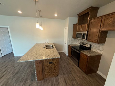 A kitchen with wooden cabinets and a granite countertop.