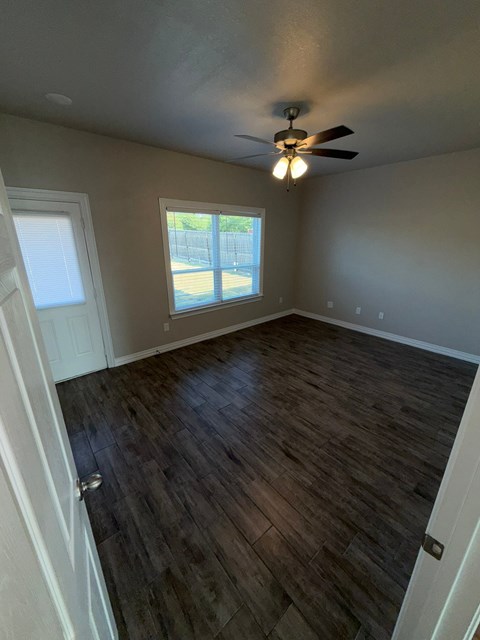 A room with a ceiling fan and a window.