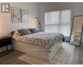 A bedroom with a bed, a nightstand, and a lamp.