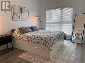 A bedroom with a bed, a nightstand, and a lamp.