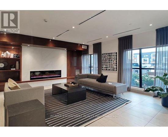 A modern living room with a fireplace and a striped rug.