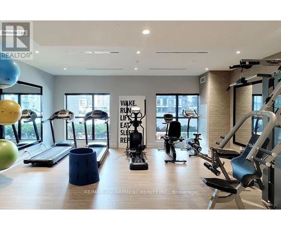 A gym with a variety of equipment including treadmills, stationary bikes, and weight machines.