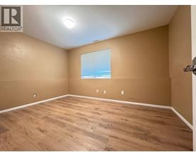 A room with wooden flooring and a window overlooking the beach.