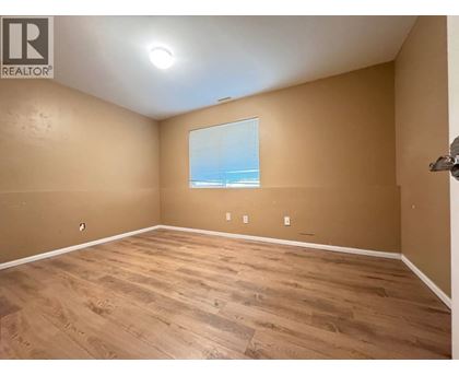 A room with wooden flooring and a window overlooking the beach.