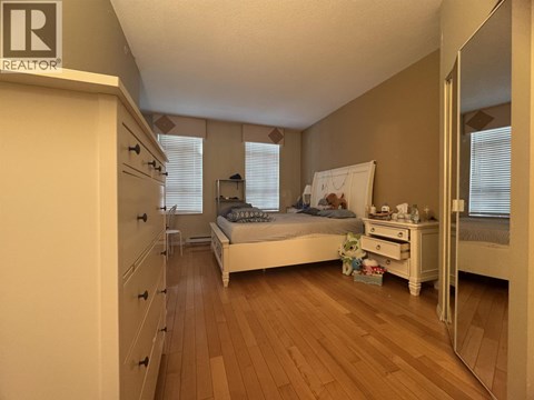A bedroom with a bed, dresser, and mirror.