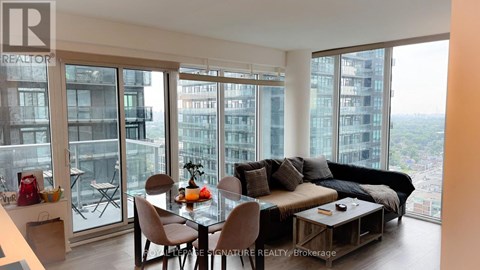 A living room with a view of the cityscape outside the large windows.