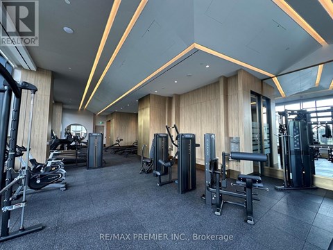A gym with a variety of equipment including treadmills, weights, and exercise machines.