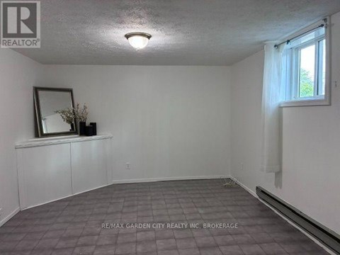 A room with a tiled floor and a window with white curtains.
