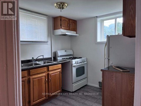 A kitchen with wooden cabinets and a stove top oven.