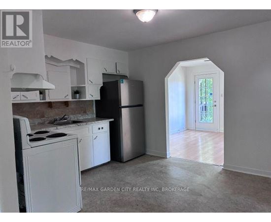 A kitchen with white appliances and cabinets is shown.
