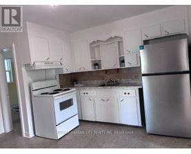 A kitchen with white appliances and cabinets.