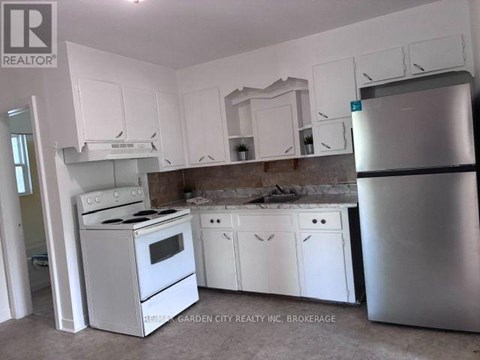 A kitchen with white appliances and cabinets.