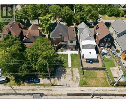 A bird's eye view of a residential area with houses and parked cars.