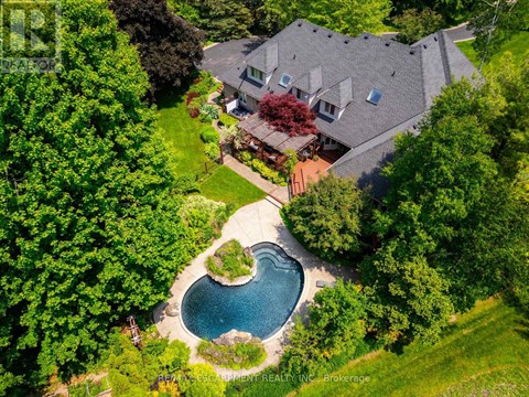 A house with a pool in the backyard surrounded by trees.
