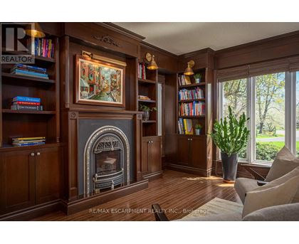A living room with a fireplace and a painting on the wall.