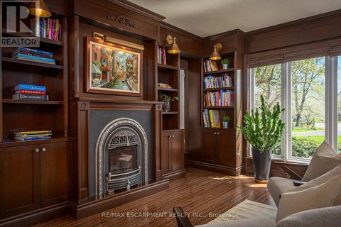 A living room with a fireplace and a painting on the wall.