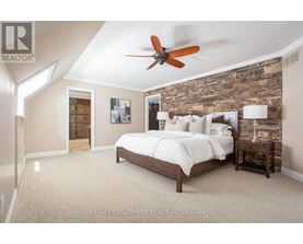 A bedroom with a bed, nightstand, and a ceiling fan.