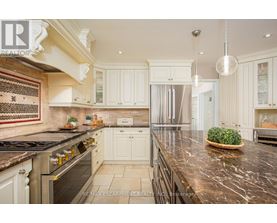 A kitchen with white cabinets and a marble countertop.